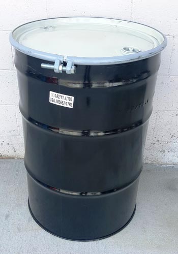 55 gallon hazardous materials metal drum with concrete background