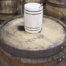 small wooden barrel on large wooden barrel with wooden barrels in the background
